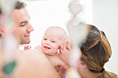 Parents kissing baby girl's cheeks