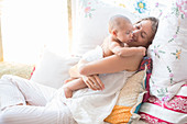 Mother holding baby boy on bed