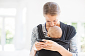 Mother with baby boy using cell phone