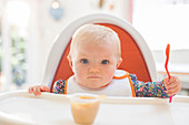 Baby girl eating in high chair