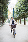 Businessman riding bicycle in park, Paris