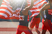 Track and field athletes holding flags