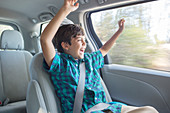 Enthusiastic boy cheering in car