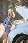 Woman talking with automobile hood raised