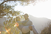 Senior man carrying woman outdoors