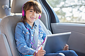 Smiling girl with headphones using tablet