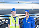 Confident workers next to tanker