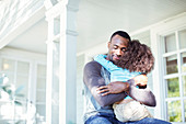 Father hugging daughter on porch