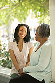 Mother and daughter talking on porch