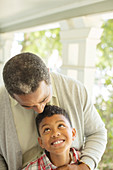 Grandfather hugging grandson on porch