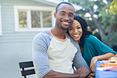 Happy couple holding hands at patio table