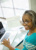 Senior woman paying bills at laptop