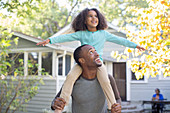 Father carrying daughter on shoulders