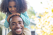 Father carrying daughter on shoulders