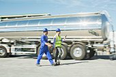 Businessman and worker walking on tanker