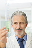 Scientist holding tube with green liquid