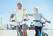 Senior couple with bicycles on beach