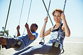 Couple on swings at beach