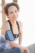 Confident female jogger wearing arm band