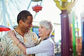Senior couple hugging at amusement park