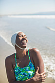 Woman in bathing suit and cap laughing