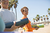 Woman with yoga mat at beach