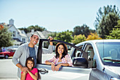 Portrait of family at car in driveway