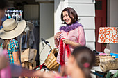 Woman trying on feather boa at yard sale