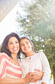 Smiling mother and daughter outdoors