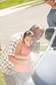 Grandfather and granddaughter washing car
