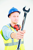 Construction worker holding large wrench