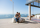 Couple using tablet on modern balcony