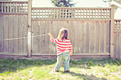 Baby girl playing with string in backyard