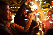 Friends playing with sparklers at party