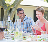 Couple laughing at table outdoors