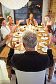 Friends applauding at dinner party