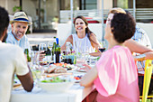 Friends relaxing at table outdoors