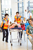 Paramedics wheeling patient in hospital