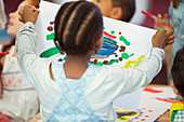 Student holding painting in class