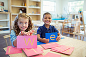 Students holding letters in classroom