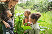 Students and teacher examining plants