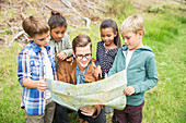 Students and teacher reading map outdoors