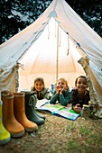 Children smiling in tent at campsite