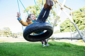 Children playing on tire swings