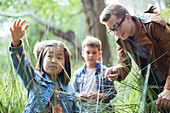 Students and teacher examining grass
