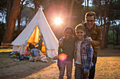 Students and teacher smiling at campsite