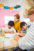 Students and teacher drawing in classroom