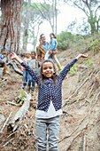 Girl holding arms out in forest