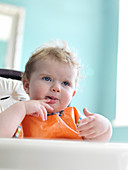 Baby girl eating in high chair