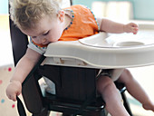 Baby girl playing in high chair
